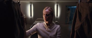 Movie still from “The Host” (2013), directed by Andrew Niccol – A woman in a white shirt is standing in a room; Medium shot, Low angle