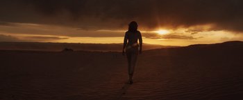 Movie still from “The Host” (2013), directed by Andrew Niccol – A woman is walking in the desert at sunset; Extreme Wide shot, Low angle