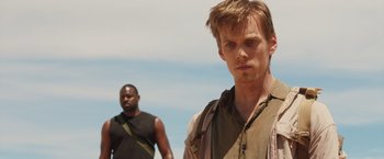 Movie still from “The Host” (2013), directed by Andrew Niccol – A man standing next to another man on a beach; Close Up shot, Over the shoulder angle