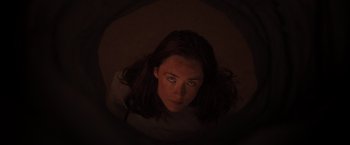 Movie still from “The Host” (2013), directed by Andrew Niccol – A woman with long brown hair is looking up at the camera; Close Up shot, Overhead angle
