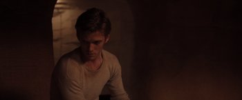 Movie still from “The Host” (2013), directed by Andrew Niccol – A man sitting in a dark room looking down at the floor; Close Up shot, Over the shoulder angle