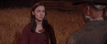 Movie still from “The Host” (2013), directed by Andrew Niccol – A woman in a red shirt is standing in front of a wall; Close Up shot, Over the shoulder angle