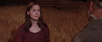 Movie still from “The Host” (2013), directed by Andrew Niccol – A woman standing in front of a bunch of dry grass; Close Up shot, Over the shoulder angle