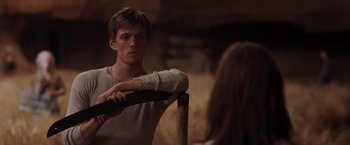 Movie still from “The Host” (2013), directed by Andrew Niccol – A young man leaning on a pole in front of a mirror; Medium shot, Over the shoulder angle