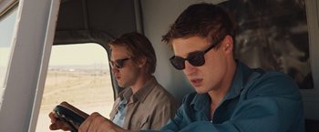 Movie still from “The Host” (2013), directed by Andrew Niccol – Two young men wearing sunglasses sitting next to each other in a vehicle; Close Up shot, Low angle