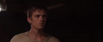 Movie still from “The Host” (2013), directed by Andrew Niccol – A young man looking into the distance in a darkened room; Close Up shot, Low angle