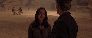 Movie still from “The Host” (2013), directed by Andrew Niccol – A woman standing next to a man on a dirt field; Close Up shot, Over the shoulder angle