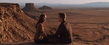 Movie still from “The Host” (2013), directed by Andrew Niccol – A man and a woman sitting on the side of a mountain; Wide shot, High angle
