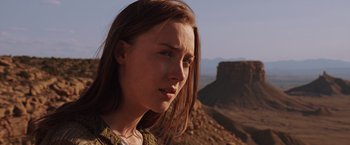 Movie still from “The Host” (2013), directed by Andrew Niccol – A woman with long brown hair standing on top of a mountain; Close Up shot, Over the shoulder angle