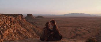 Movie still from “The Host” (2013), directed by Andrew Niccol – A man and a woman sitting on top of a mountain; Wide shot, High angle