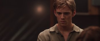 Movie still from “The Host” (2013), directed by Andrew Niccol – A young man with short blonde hair wearing a tan shirt; Close Up shot, Over the shoulder angle
