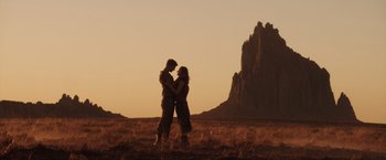 Movie still from “The Host” (2013), directed by Andrew Niccol – A man and a woman embracing in a field; Wide shot, Low angle