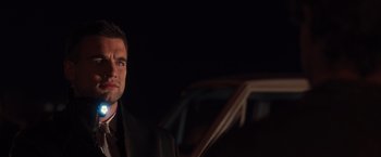 Movie still from “The Host” (2013), directed by Andrew Niccol – A man wearing a suit and tie standing next to a car; Close Up shot, Over the shoulder angle
