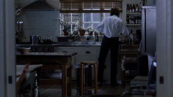 Movie still from “The Hours” (2002), directed by Stephen Daldry – A man standing at a sink in a kitchen; Wide shot, Low angle