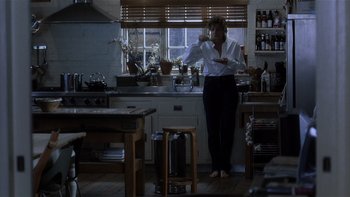 Movie still from “The Hours” (2002), directed by Stephen Daldry – A woman standing in a kitchen holding a frying pan; Wide shot, High angle