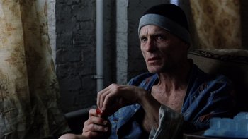 Movie still from “The Hours” (2002), directed by Stephen Daldry – An old man sitting in front of a brick wall; Close Up shot, High angle