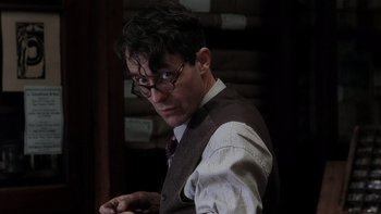 Movie still from “The Hours” (2002), directed by Stephen Daldry – A man wearing glasses and a vest looking at the camera; Close Up shot, Over the shoulder angle