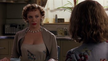 Movie still from “The Hours” (2002), directed by Stephen Daldry – A woman wearing a necklace and a dress in front of another woman in front of a window; Close Up shot, Over the shoulder angle