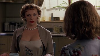 Movie still from “The Hours” (2002), directed by Stephen Daldry – A woman wearing a necklace and a dress in front of a mirror; Close Up shot, Over the shoulder angle