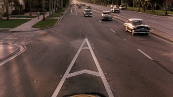 Movie still from “The Hours” (2002), directed by Stephen Daldry – Cars driving down a street in the middle of the day; Extreme Wide shot, High angle