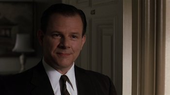 Movie still from “The Hours” (2002), directed by Stephen Daldry – A person wearing a suit and tie; Close Up shot, Over the shoulder angle