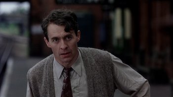 Movie still from “The Hours” (2002), directed by Stephen Daldry – A person wearing a suit and tie; Close Up shot, Over the shoulder angle