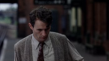 Movie still from “The Hours” (2002), directed by Stephen Daldry – A person wearing a suit and tie; Close Up shot, Over the shoulder angle