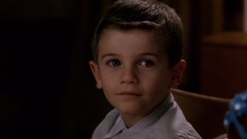 Movie still from “The Hours” (2002), directed by Stephen Daldry – A young boy with blue eyes sitting in a chair; Close Up shot, High angle