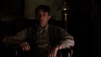 Movie still from “The Hours” (2002), directed by Stephen Daldry – A man sitting in a chair with a cigarette in his mouth; Medium shot, Low angle