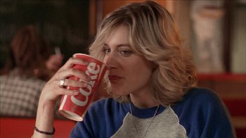 Movie still from “The House of the Devil” (2009), directed by Ti West – A woman is drinking a coke from a red cup; Close Up shot, Over the shoulder angle