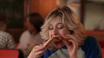 Movie still from “The House of the Devil” (2009), directed by Ti West – A woman is eating a hot dog in a restaurant; Close Up shot, Over the shoulder angle
