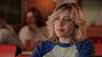 Movie still from “The House of the Devil” (2009), directed by Ti West – A person sitting at a table in a restaurant; Close Up shot, Over the shoulder angle