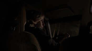 Movie still from “The House of the Devil” (2009), directed by Ti West – A woman sitting in the back seat of a car at night; Close Up shot, Over the shoulder angle