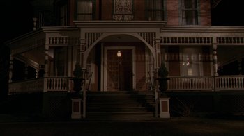 Movie still from “The House of the Devil” (2009), directed by Ti West – A building that has a clock on the front of it; Wide shot, High angle