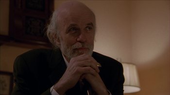Movie still from “The House of the Devil” (2009), directed by Ti West – An older man in a black suit and a white beard; Close Up shot, Low angle