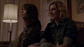 Movie still from “The House of the Devil” (2009), directed by Ti West – Two women sitting in a living room next to each other; Medium shot, Low angle