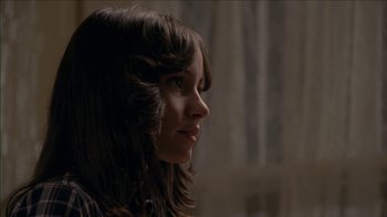 Movie still from “The House of the Devil” (2009), directed by Ti West – A person with long brown hair; Close Up shot, Over the shoulder angle
