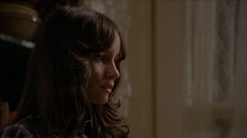Movie still from “The House of the Devil” (2009), directed by Ti West – A woman with long brown hair looking to her left; Close Up shot, Over the shoulder angle