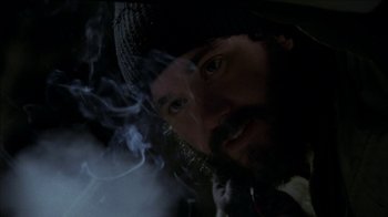 Movie still from “The House of the Devil” (2009), directed by Ti West – A man with a beard is smoking a cigarette; Close Up shot, Low angle