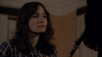 Movie still from “The House of the Devil” (2009), directed by Ti West – A young woman holding an umbrella while looking off to her right; Close Up shot, Over the shoulder angle