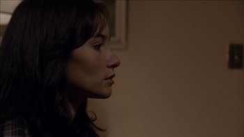 Movie still from “The House of the Devil” (2009), directed by Ti West – A person's face in a dark room; Close Up shot, Over the shoulder angle