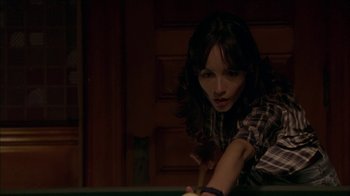 Movie still from “The House of the Devil” (2009), directed by Ti West – A woman leaning over a pool table in a dark room; Close Up shot, High angle