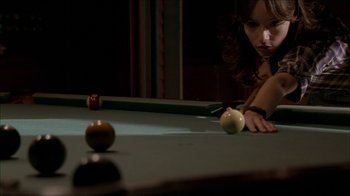 Movie still from “The House of the Devil” (2009), directed by Ti West – A woman leaning over a billiard table to hit a ball; Close Up shot, Over the shoulder angle
