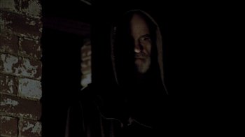 Movie still from “The House of the Devil” (2009), directed by Ti West – A man with a beard is wearing a hooded sweatshirt; Close Up shot, Low angle