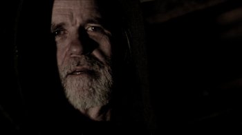 Movie still from “The House of the Devil” (2009), directed by Ti West – An old man with a beard is looking at the camera; Close Up shot, Low angle