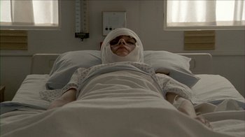 Movie still from “The House of the Devil” (2009), directed by Ti West – A person in a hospital bed with a bandage on their head; Close Up shot, Low angle
