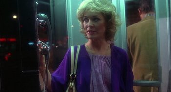 Movie still from “The Howling” (1981), directed by Joe Dante – A woman in a purple dress is on a train; Close Up shot, Low angle