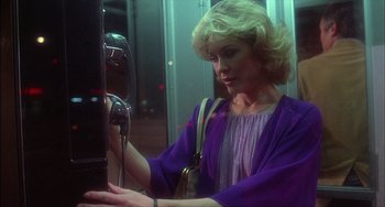 Movie still from “The Howling” (1981), directed by Joe Dante – A woman in a purple dress looking at a pay phone; Medium shot, Low angle