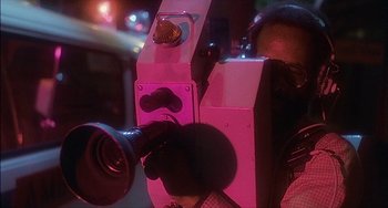 Movie still from “The Howling” (1981), directed by Joe Dante – A person is holding a camera in a parking lot; Extreme Close Up shot, Low angle