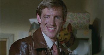 Movie still from “The Howling” (1981), directed by Joe Dante – A person wearing a suit and tie; Close Up shot, Low angle